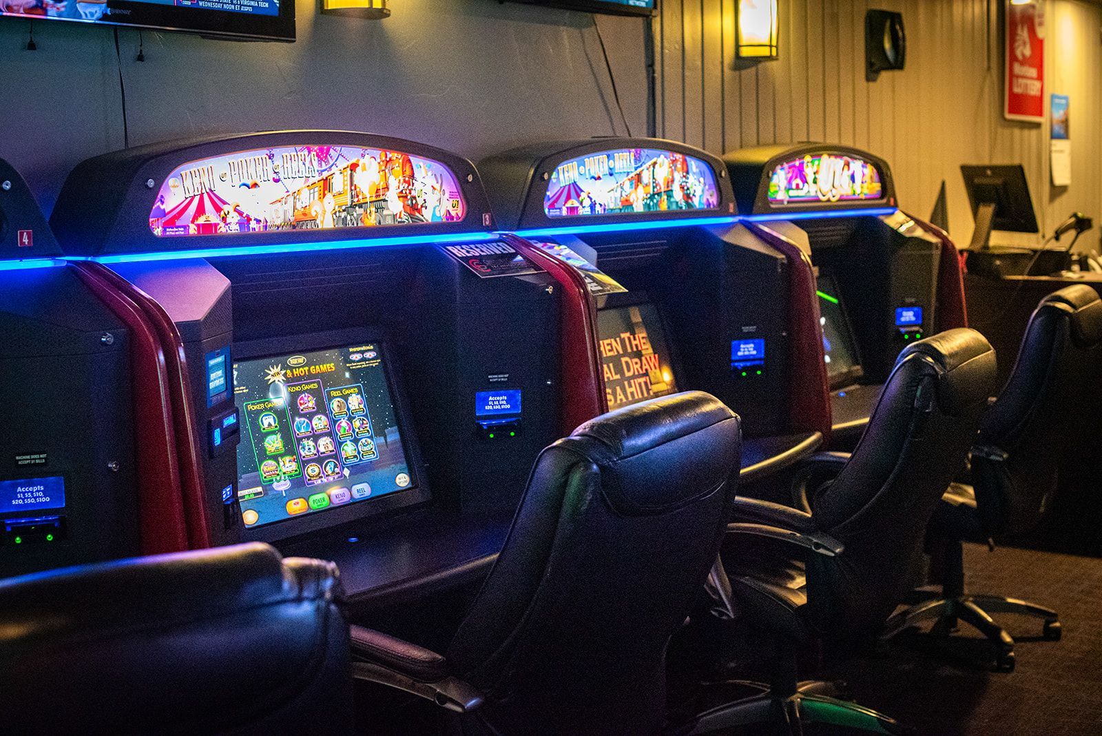 A row of arcade games are lined up in a room.