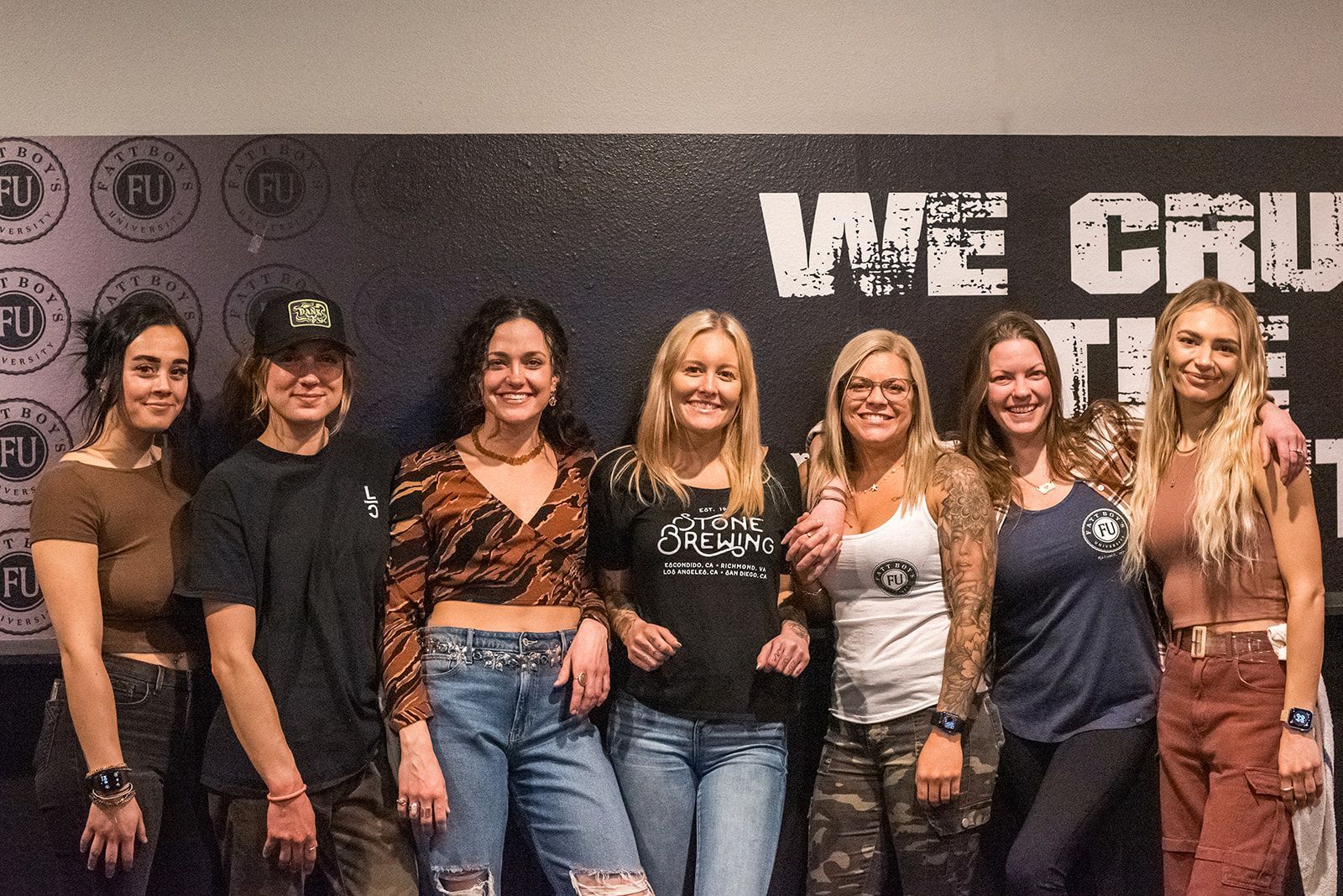 A group of people are posing for a picture in front of a wall.