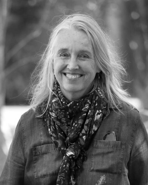 A black and white photo of a woman wearing a scarf and smiling.