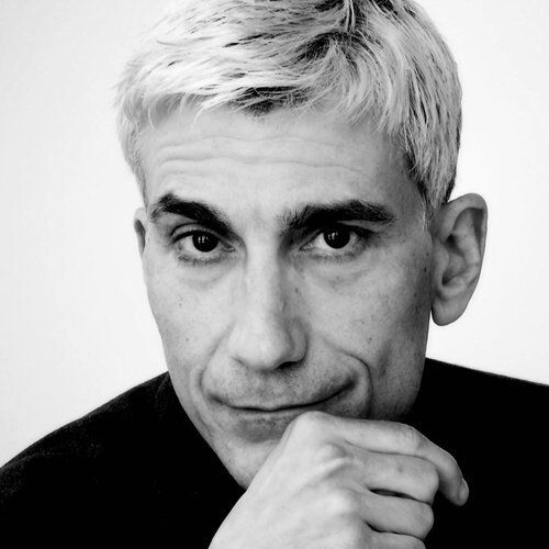 A black and white photo of a man with his hand on his chin