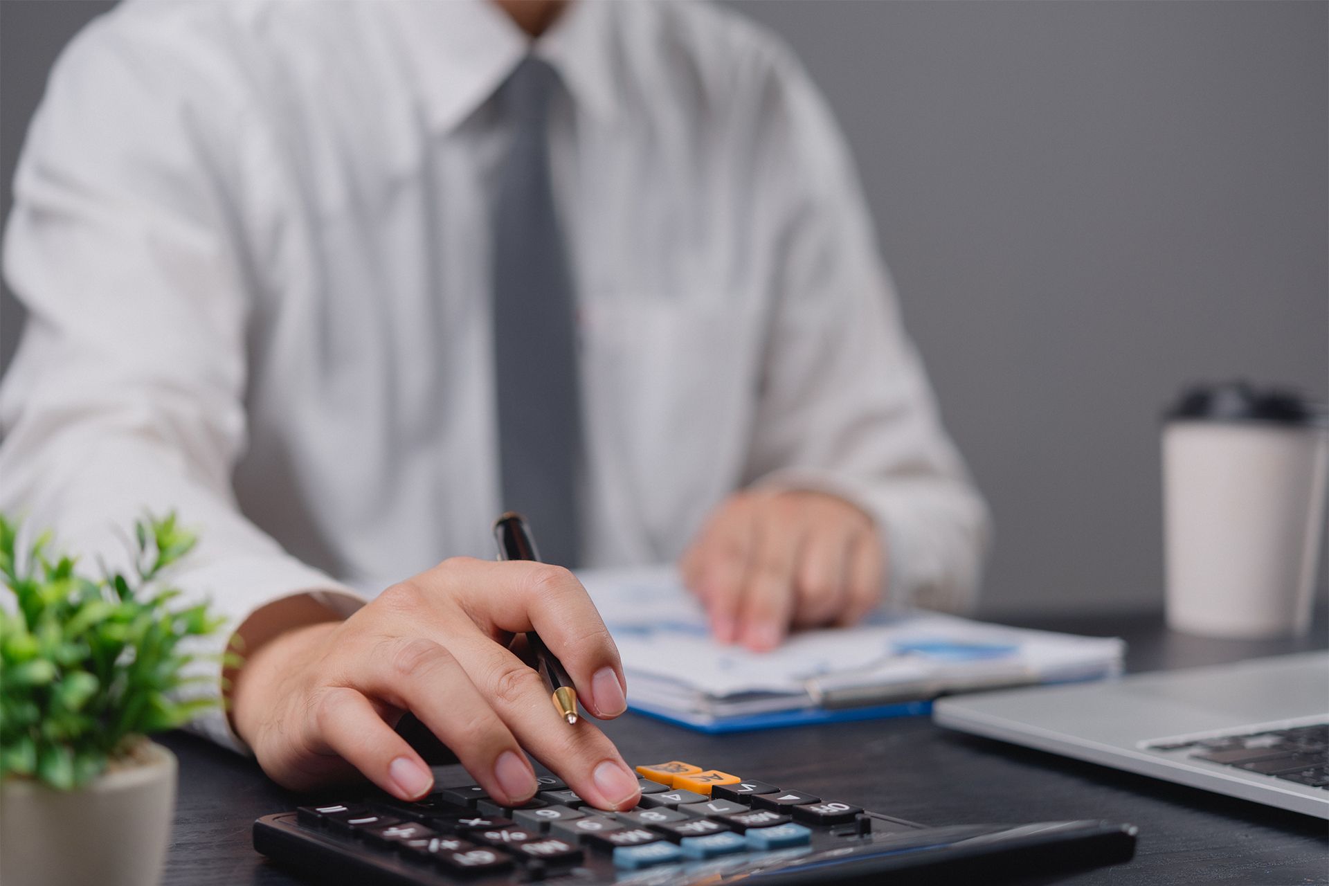 Accountant Sitting at a Desk Using a Calculator Accountant Sitting at a Desk Using a Calculator