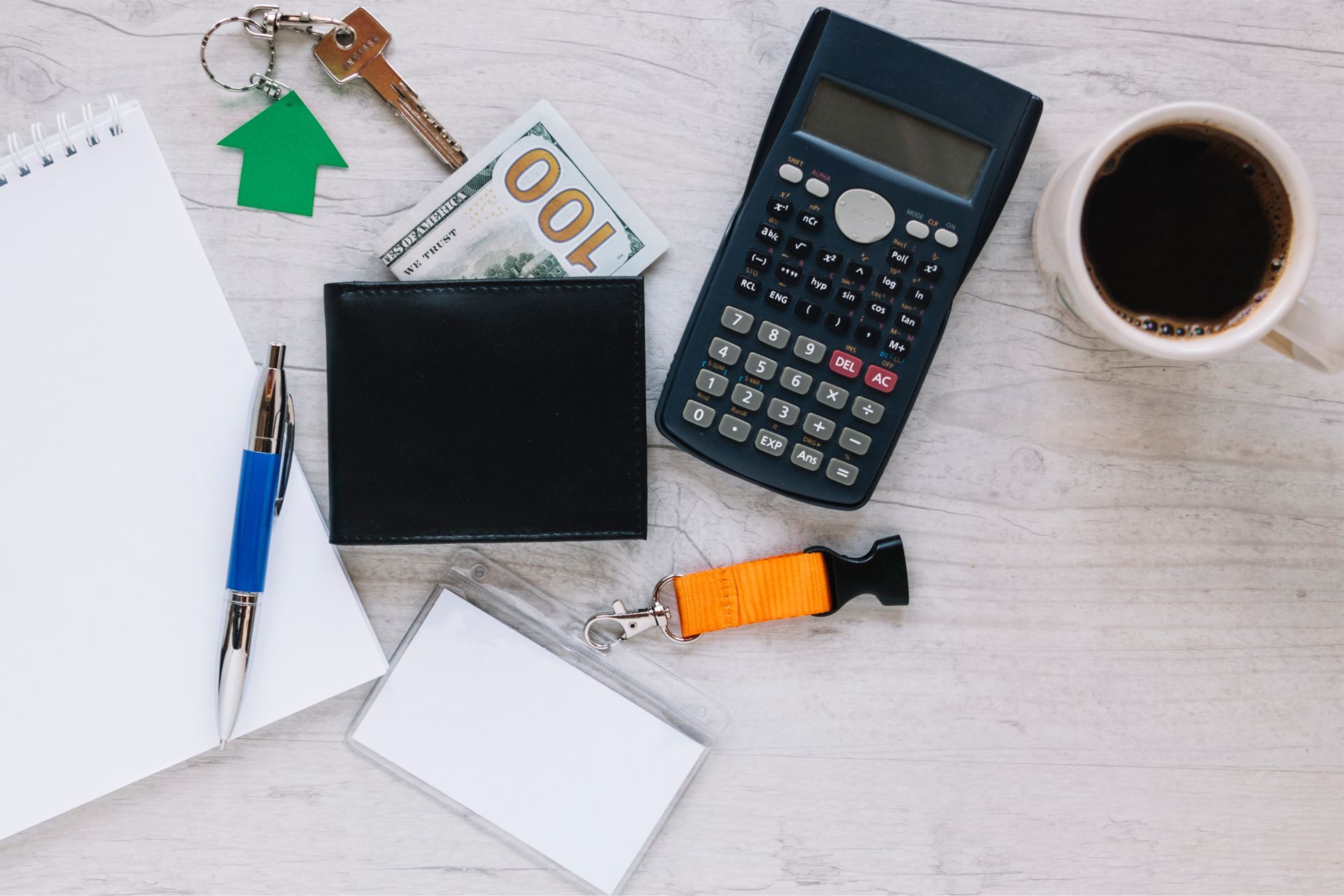 Overhead View of Notepad, Pen, Keys, Money, Wallet, Calculator, Coffee and Name Tag