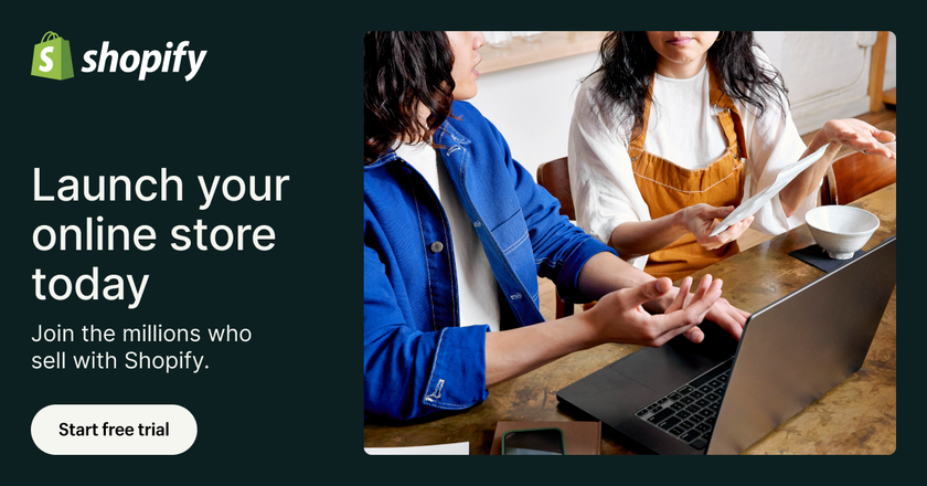 A man and a woman are sitting at a table with a laptop.