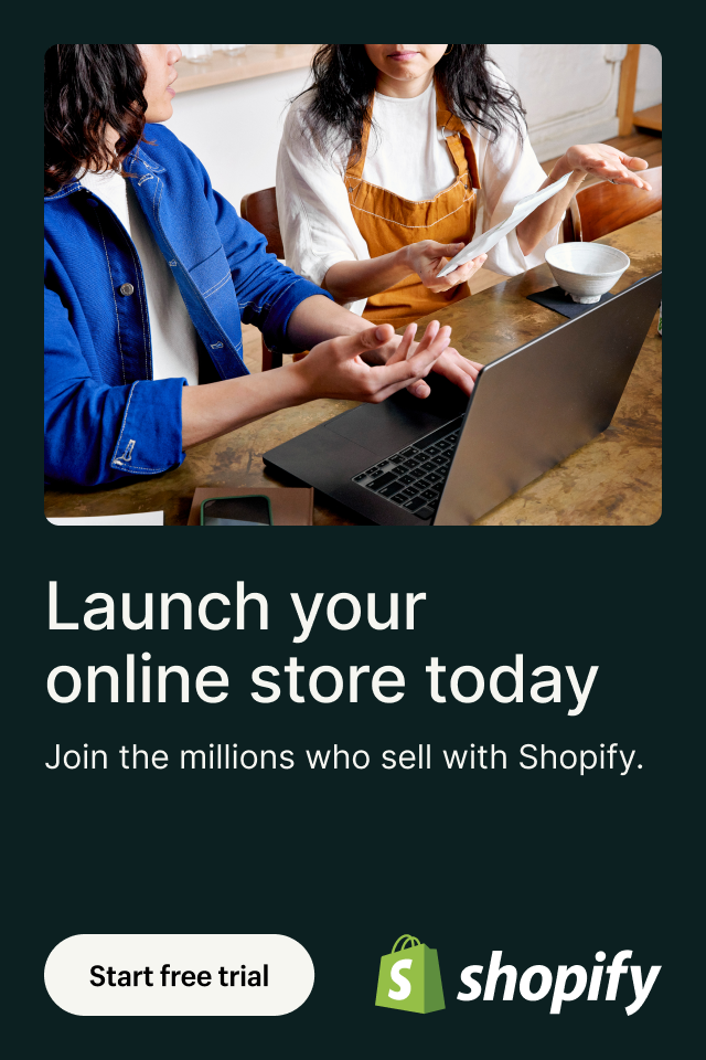 A group of people are sitting at a table using a laptop computer.