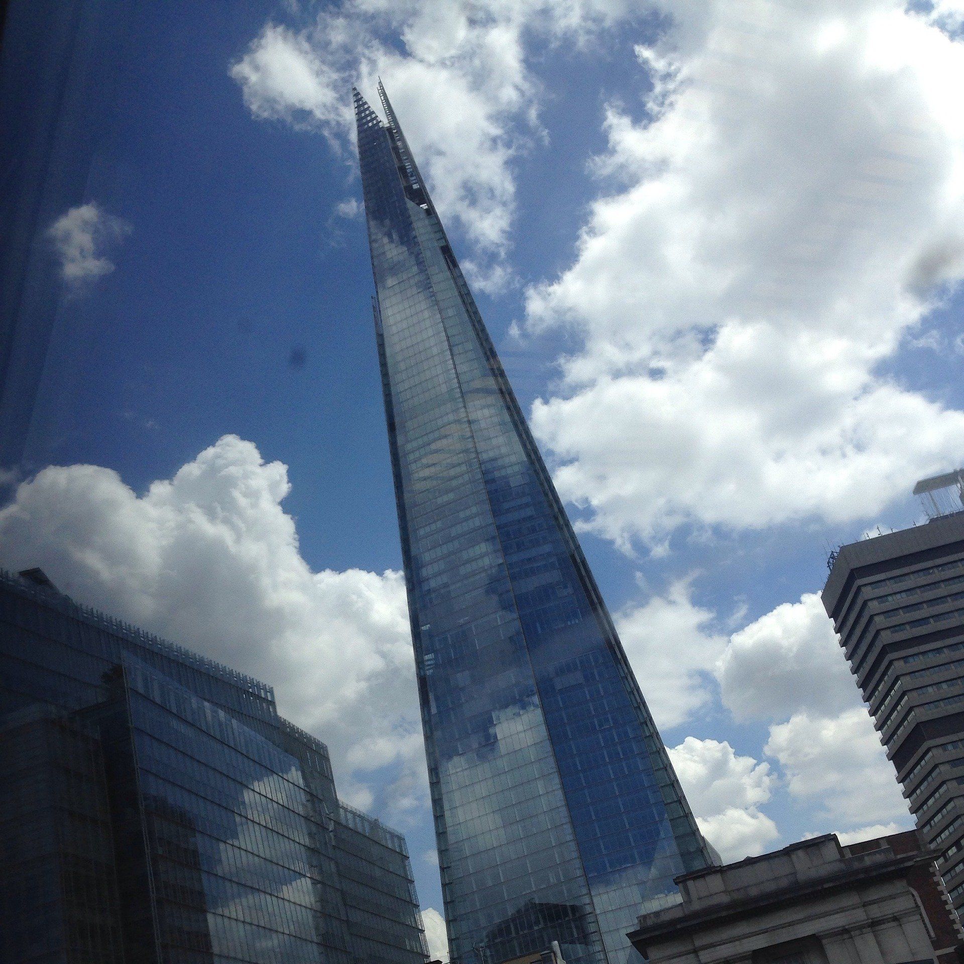 A tall building with a blue sky and clouds behind it