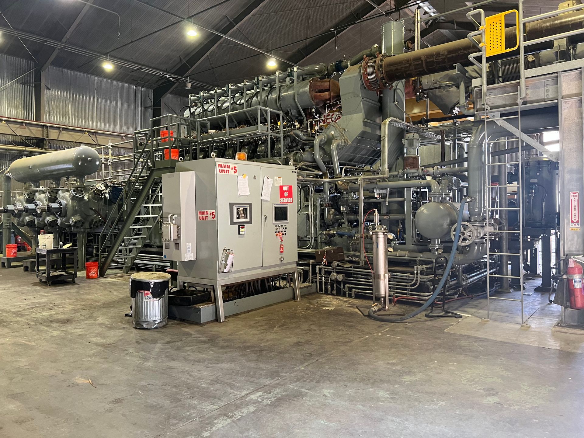 Industrial machinery in a factory setting, including tanks, pipes, and control panels.