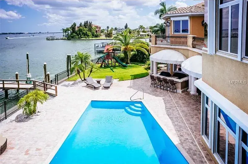 A large house with a large swimming pool in front of it