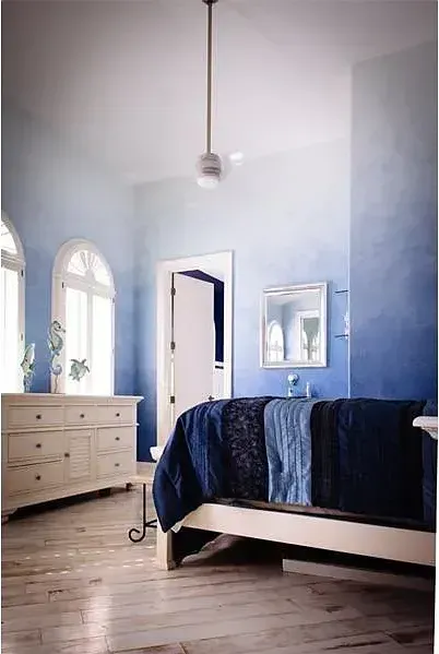A bedroom with blue and white walls and a bed