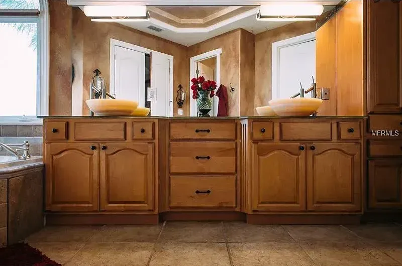 A bathroom with two sinks and a large mirror.