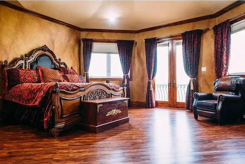 A bedroom with a large bed , chair , and window.