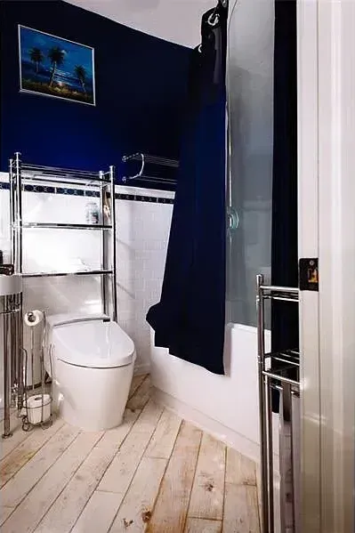 A bathroom with a toilet , sink and shower.