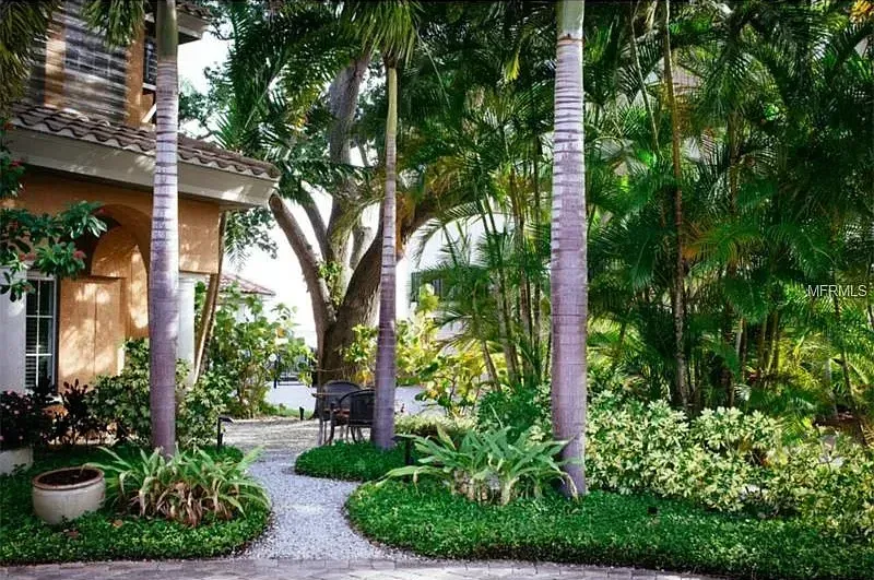 A path leading to a house surrounded by trees and bushes