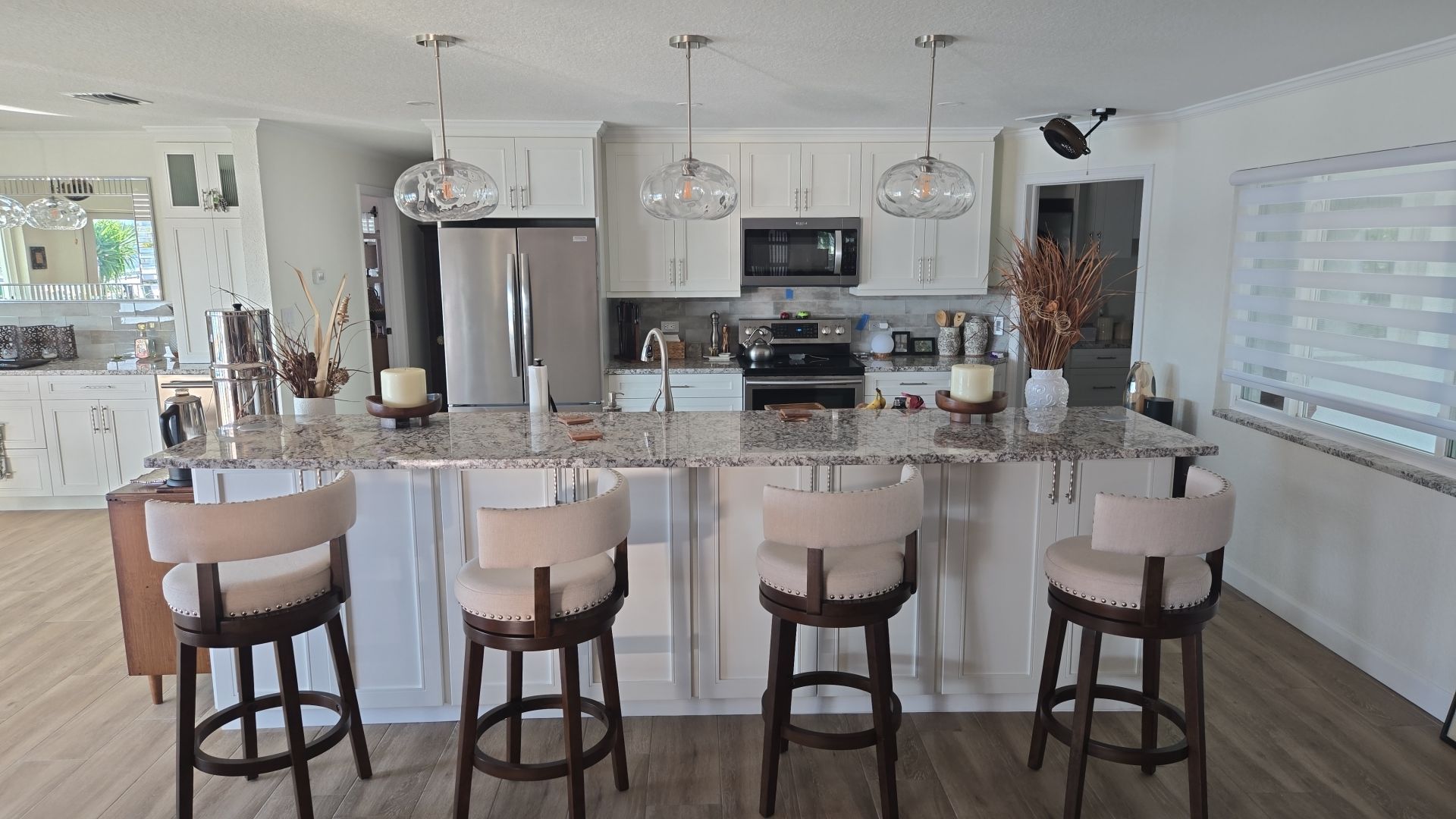 A kitchen with a table and chairs and a staircase in the background.