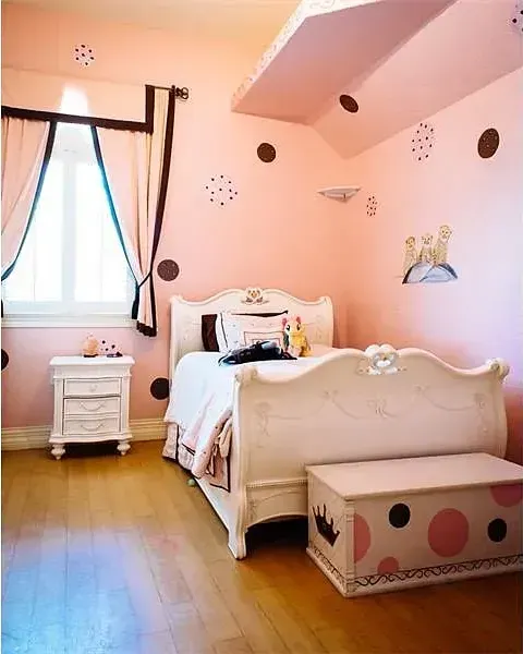 A bedroom with pink walls and a white bed