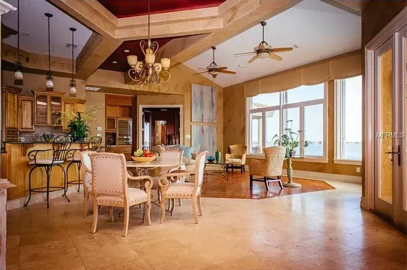 A large room with a dining table and chairs and a ceiling fan.