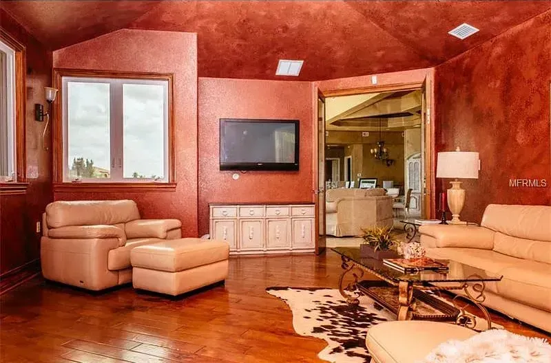 A living room with a couch , chairs , coffee table and television.