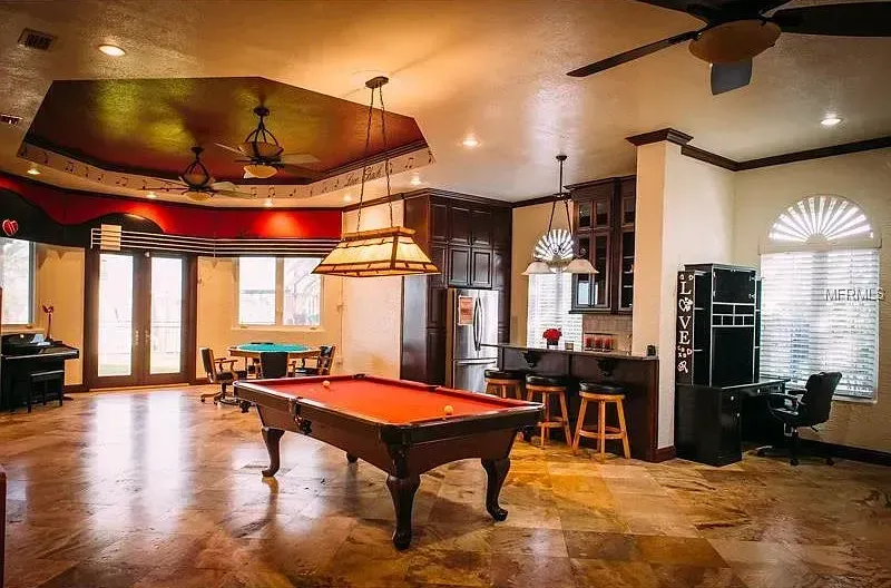 There is a pool table in the middle of the room.