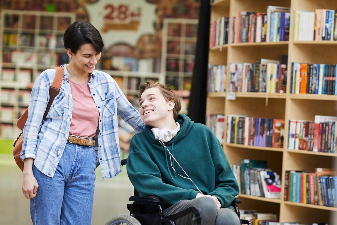 Happy Man And Woman Inside A Library — Disability Support in Townsville, QLD