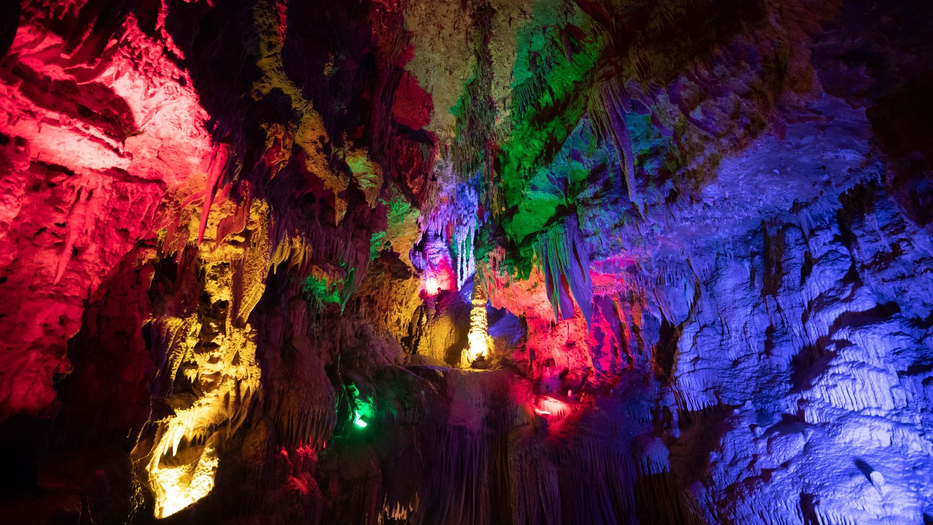 A cave filled with colorful lights at night.