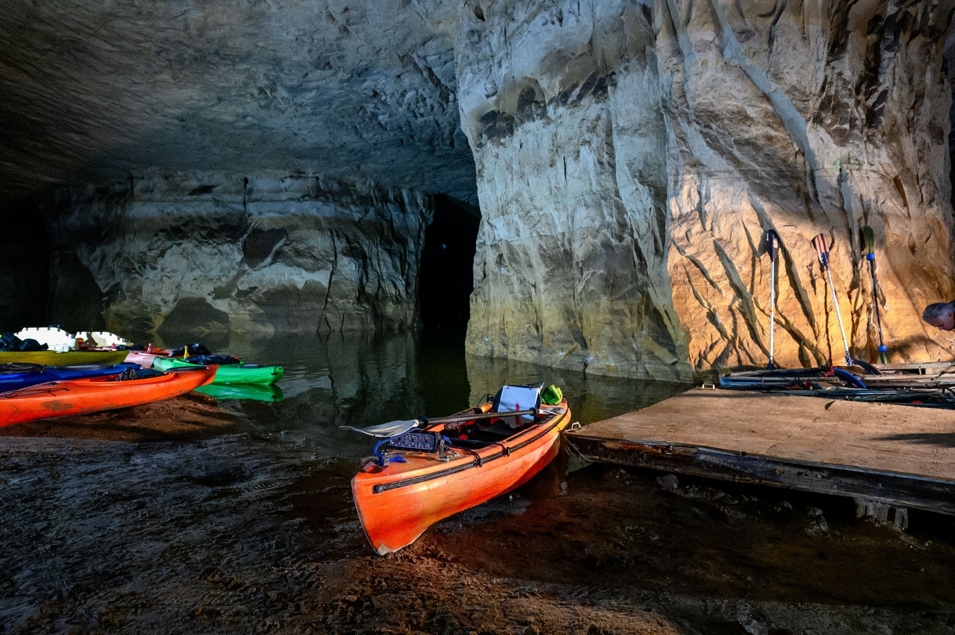 A group of kayaks are sitting in a cave.