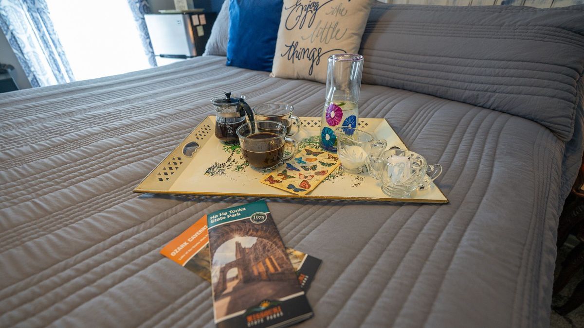 a tray on a bed with a book and coffee