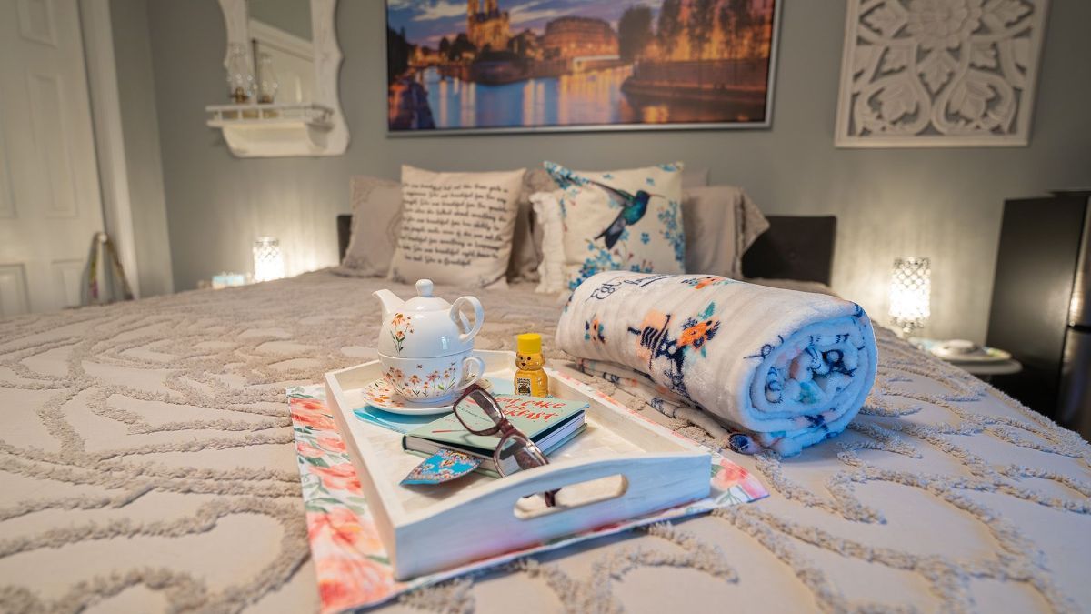 a tray on a bed with a book and hot tea