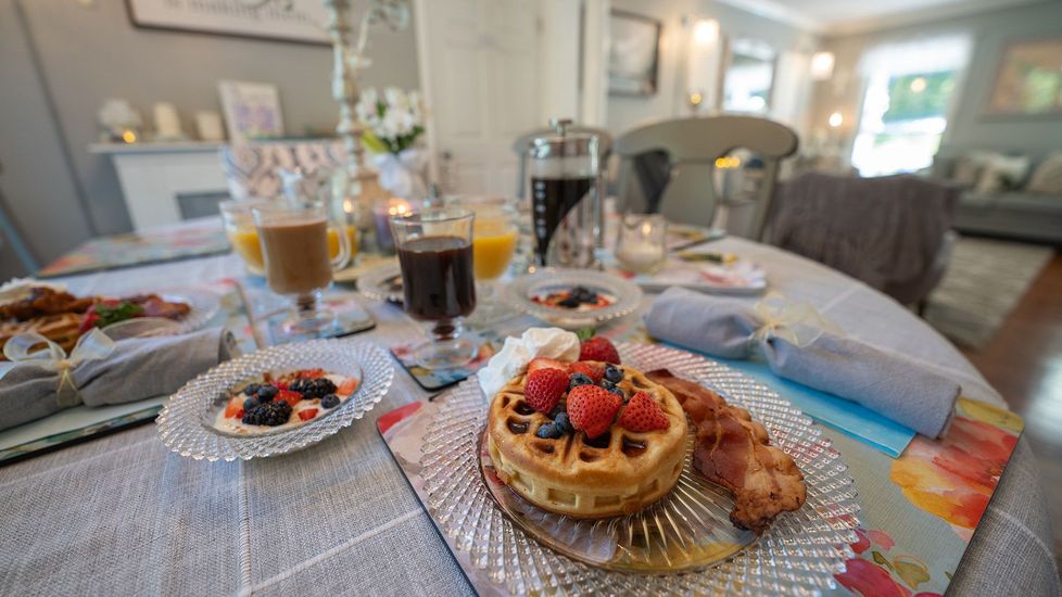 a plate of waffles with strawberries and blueberries on a table