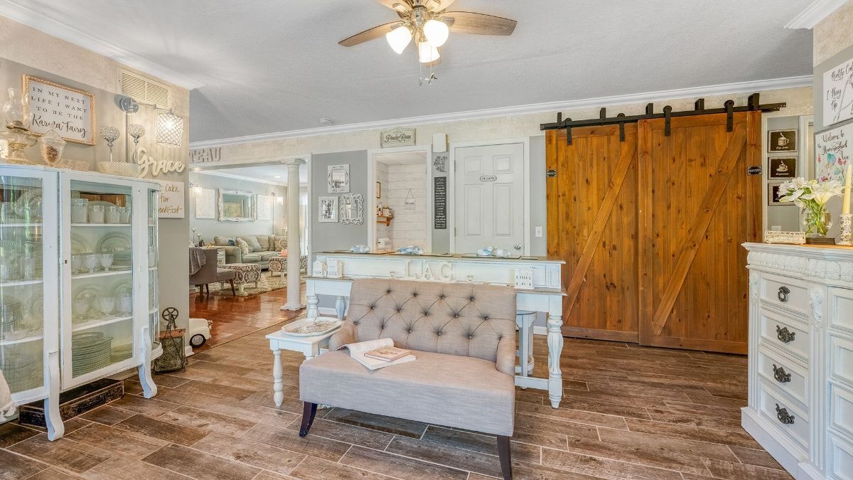 living room with a ceiling fan and a sliding barn door
