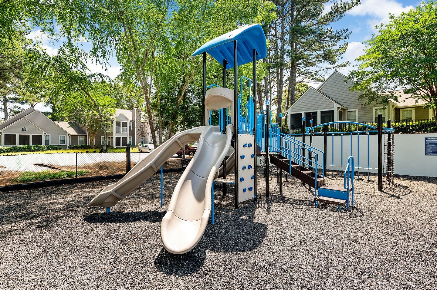 Playground with slide, climbing features & blue and beige at Station Heights in Alpharetta, GA.