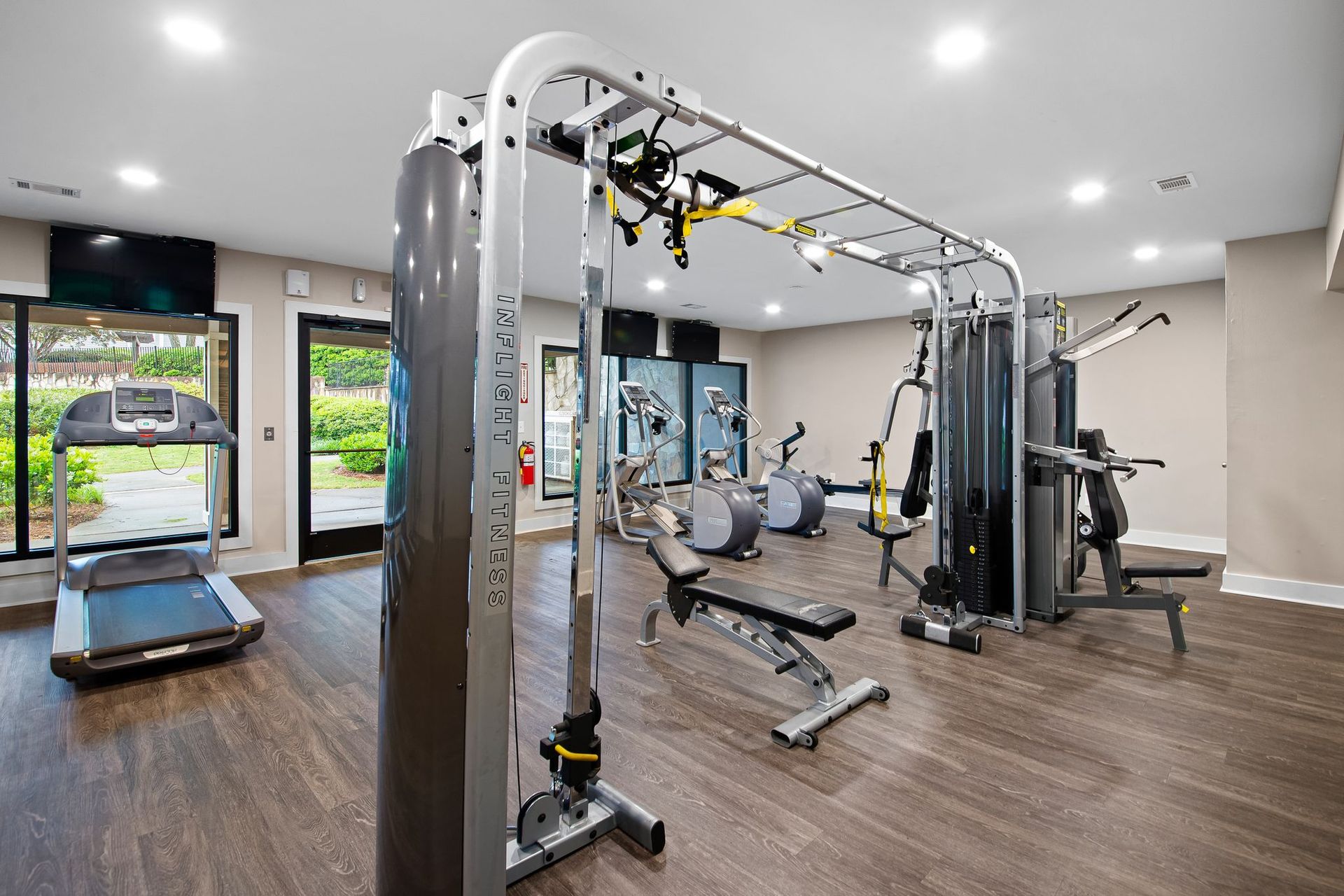 Gym with various exercise machines, including treadmill, weight machines, and TRX at Station Heights in Alpharetta, GA.