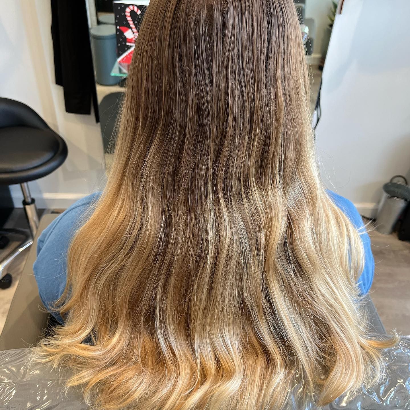 Woman with long hair featuring a dark to light blonde ombre style.