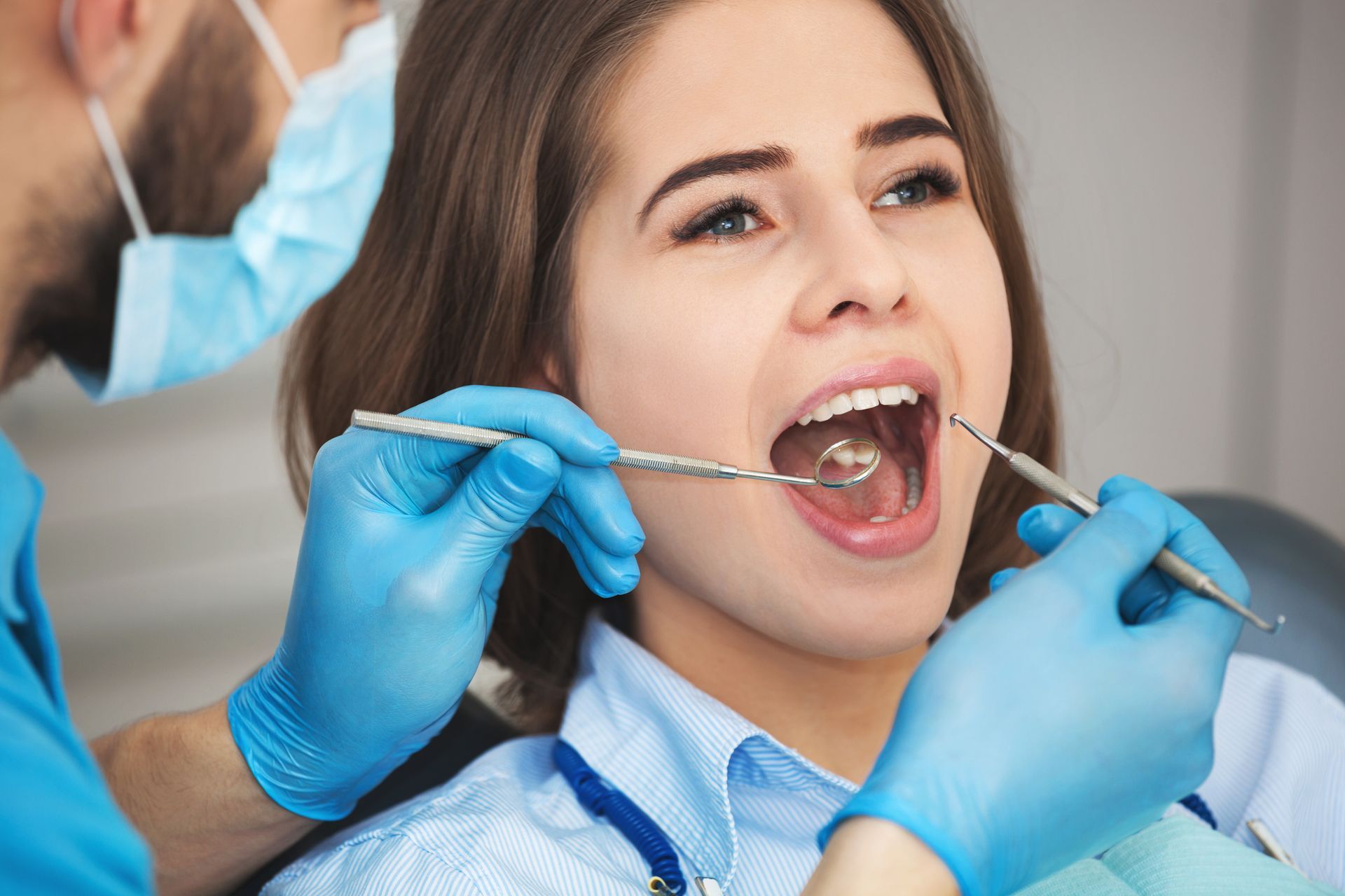 a woman is getting her teeth examined by a dentist .