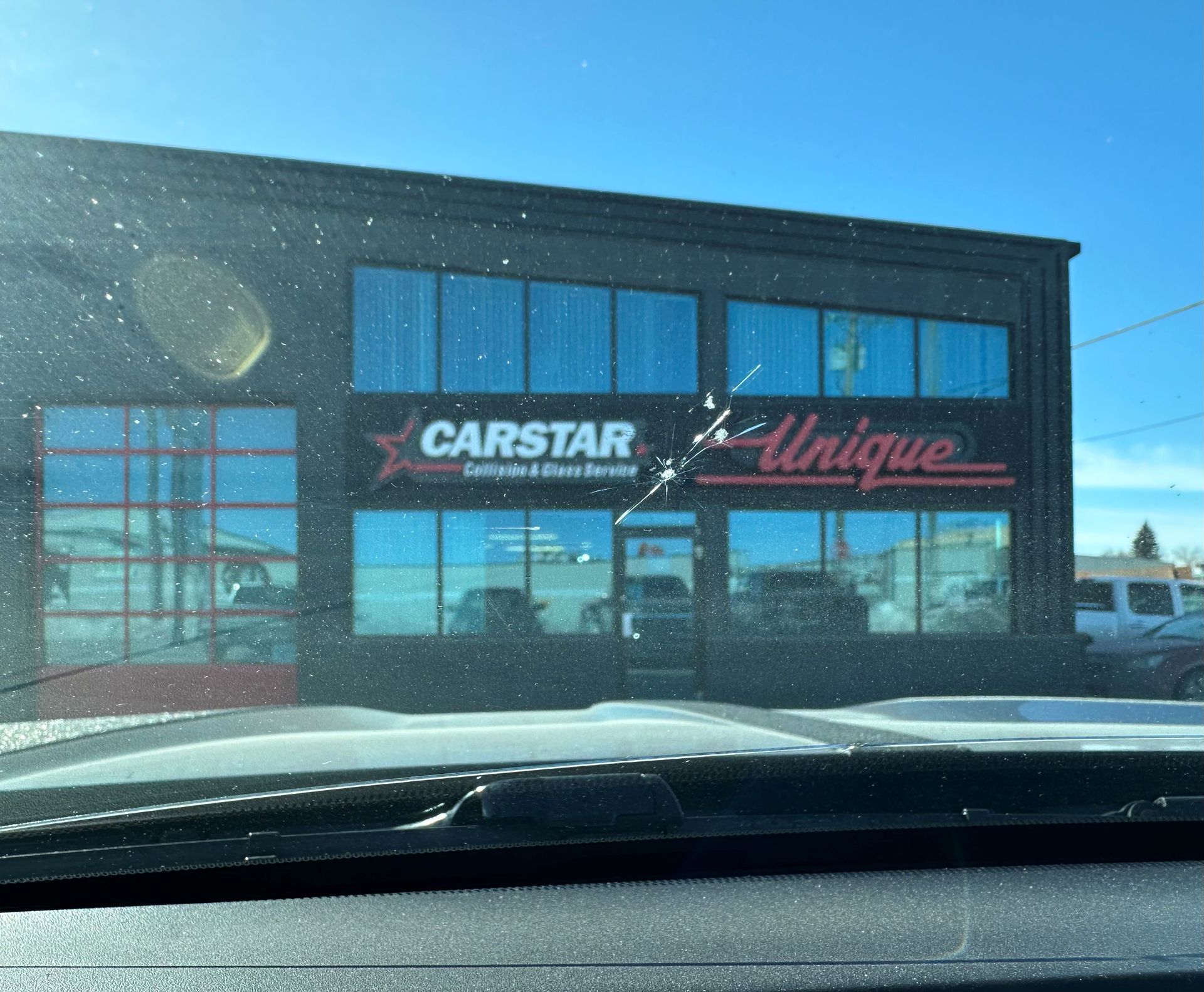 A car is parked in front of a carstar and unique store