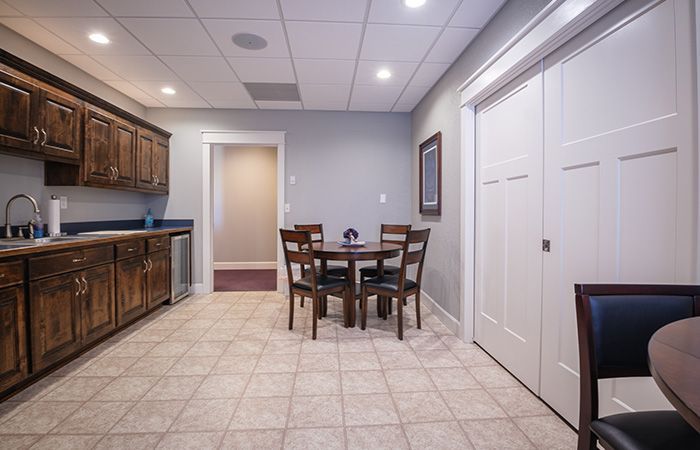 A kitchen with a table and chairs and a sink.