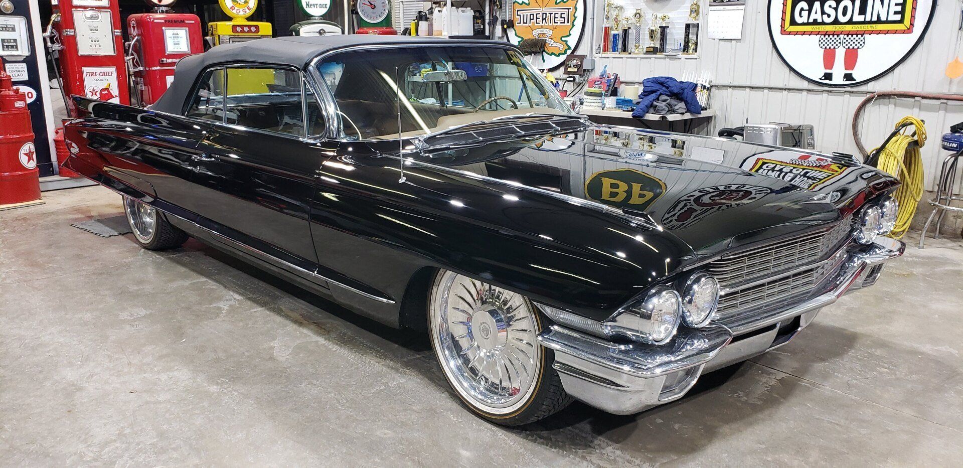 Black convertible car with chrome accents parked inside a garage.