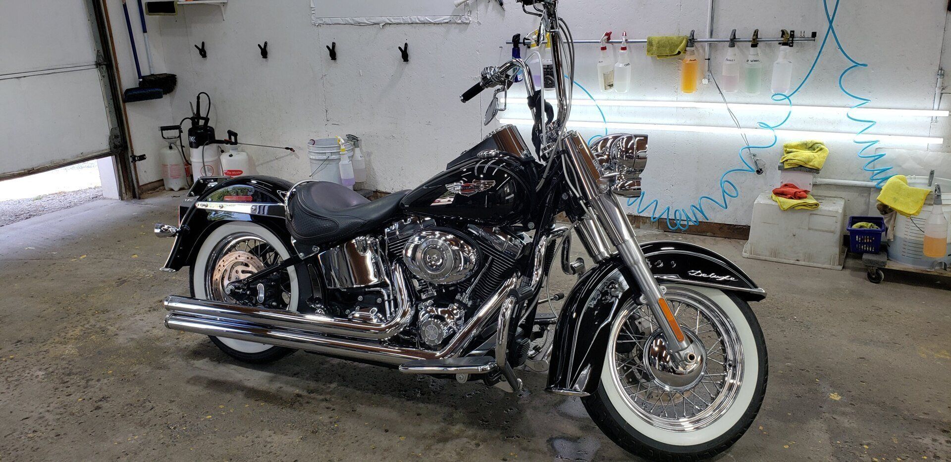Black Harley-Davidson motorcycle with white-walled tires parked inside a garage.