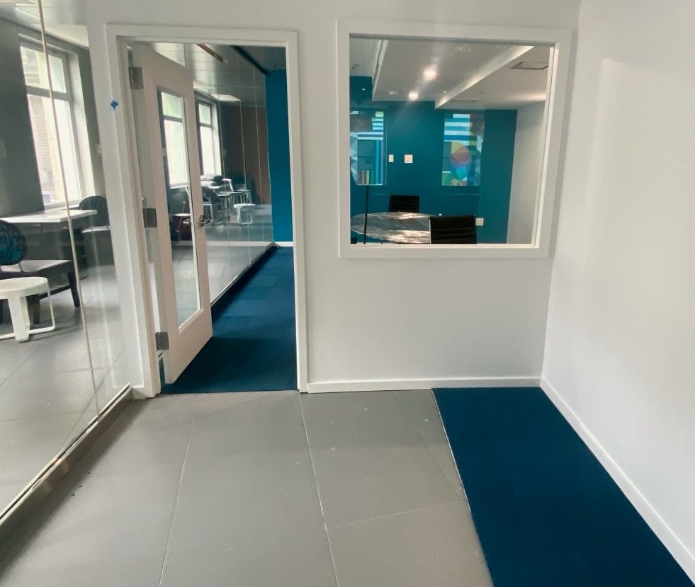 A hallway with a window and a blue carpet