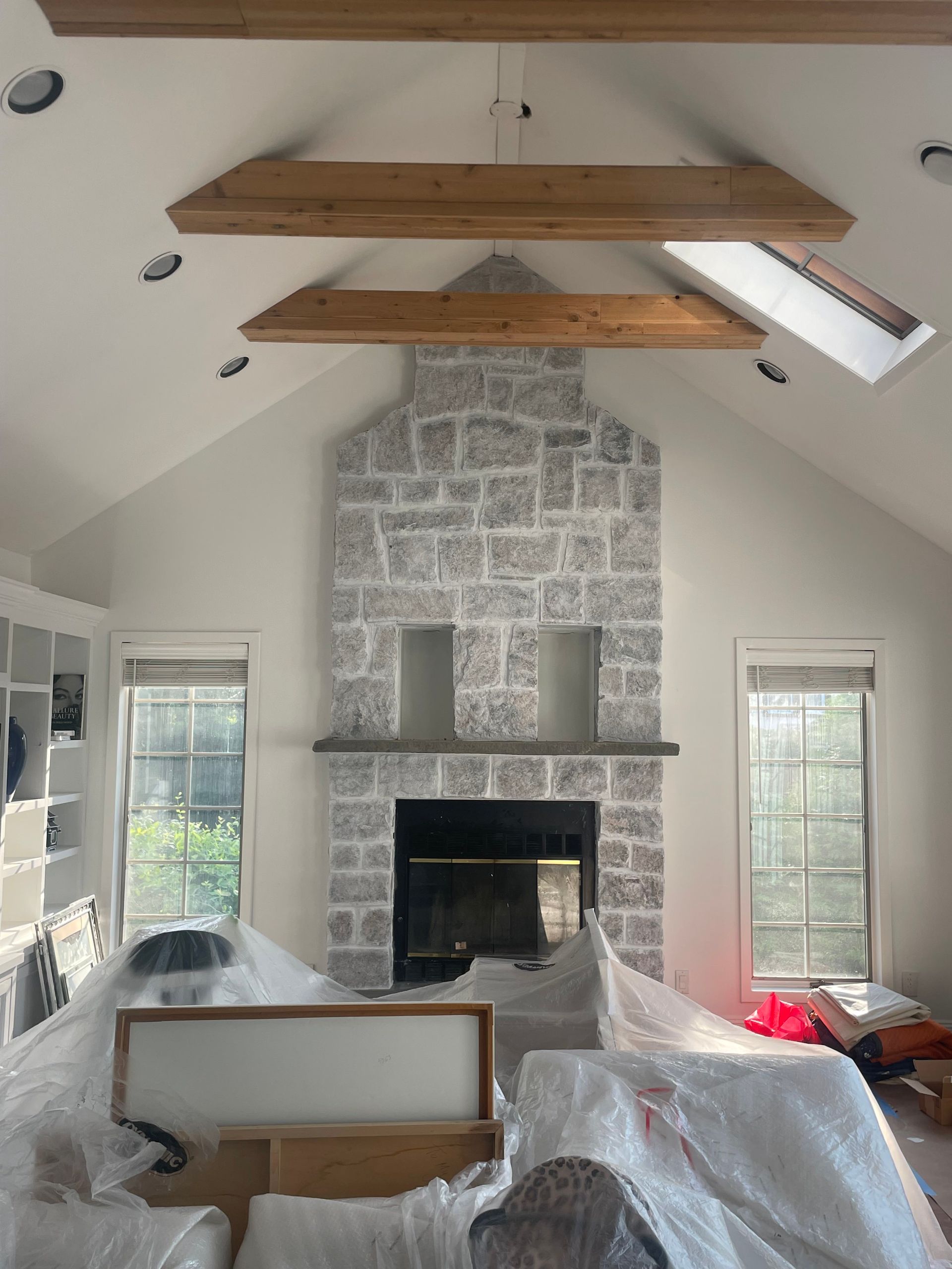 A living room with a brick fireplace and wooden beams