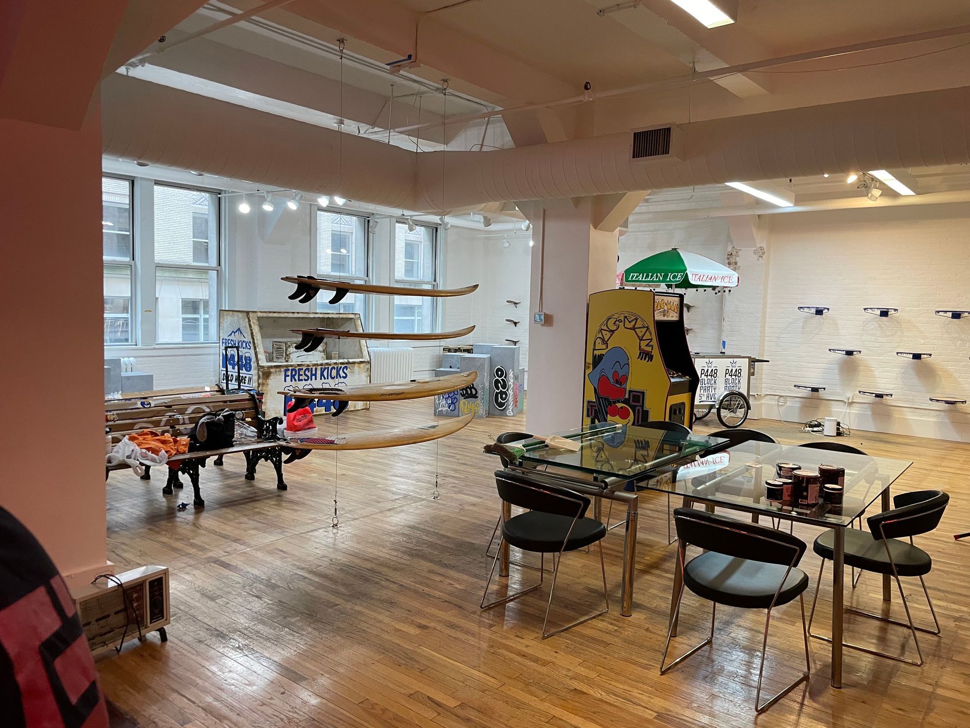 A large room with tables and chairs and an arcade machine