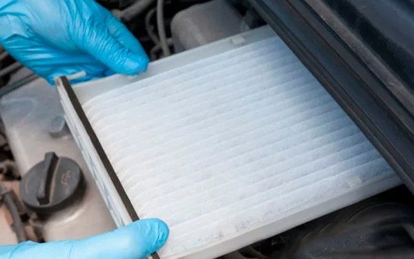 Persona revisando aire acondicionado de vehículo