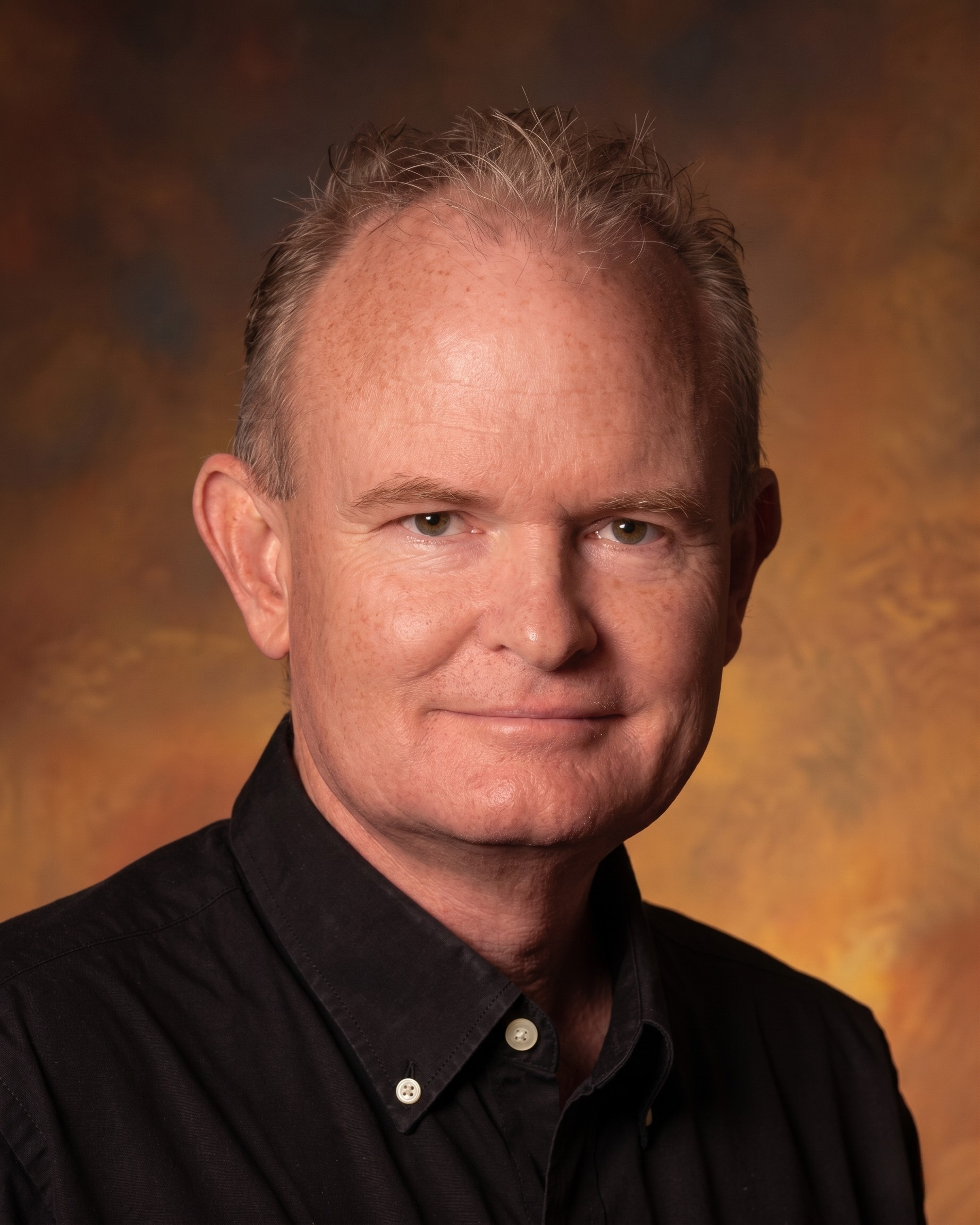Portrait of  Johnny “The Flash” Thornton in a dark shirt against a warm brown studio background