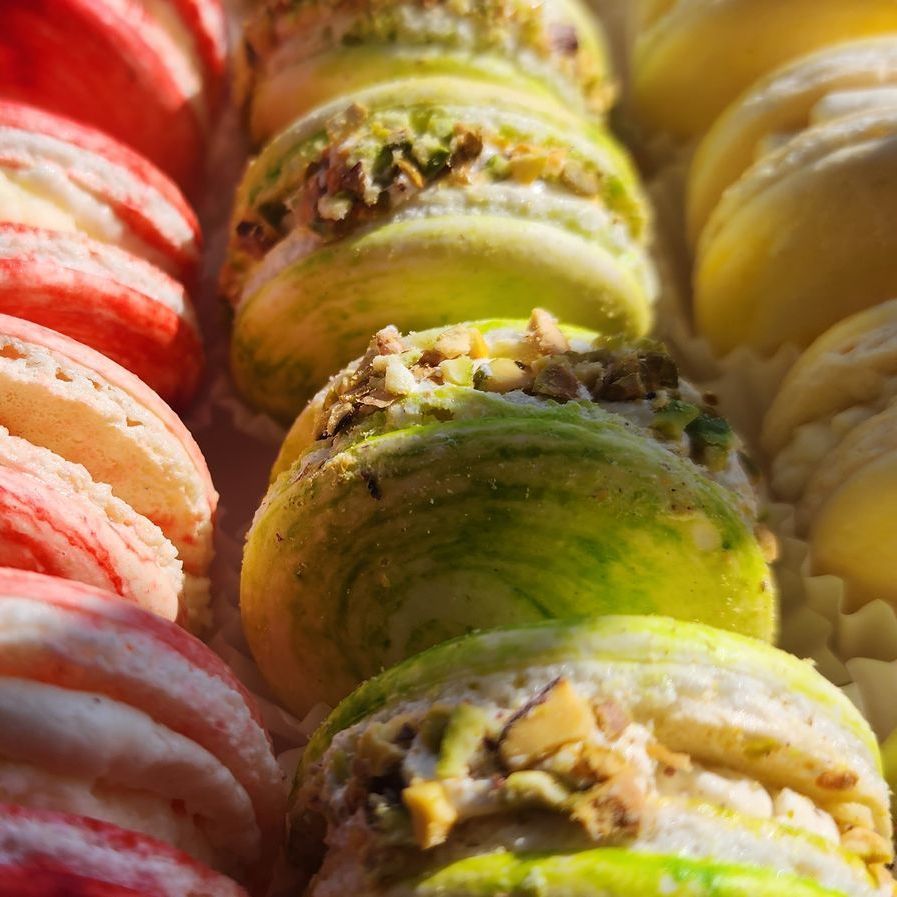 A close up of a tray of macarons with different flavors.