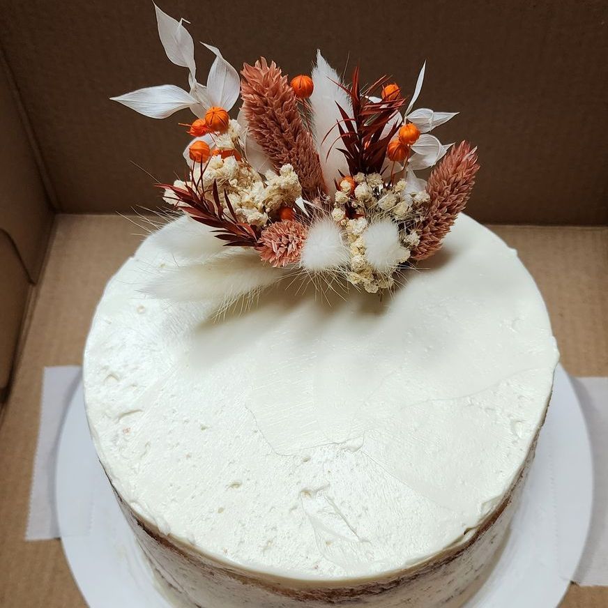 A white cake with flowers on top of it, custom made