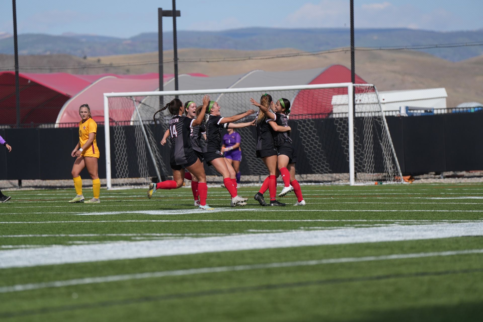 A group of women are playing soccer on a field.