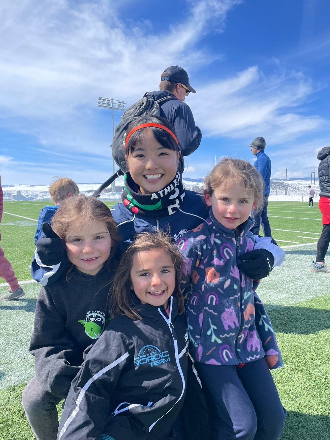 A group of young girls are posing for a picture on a field.