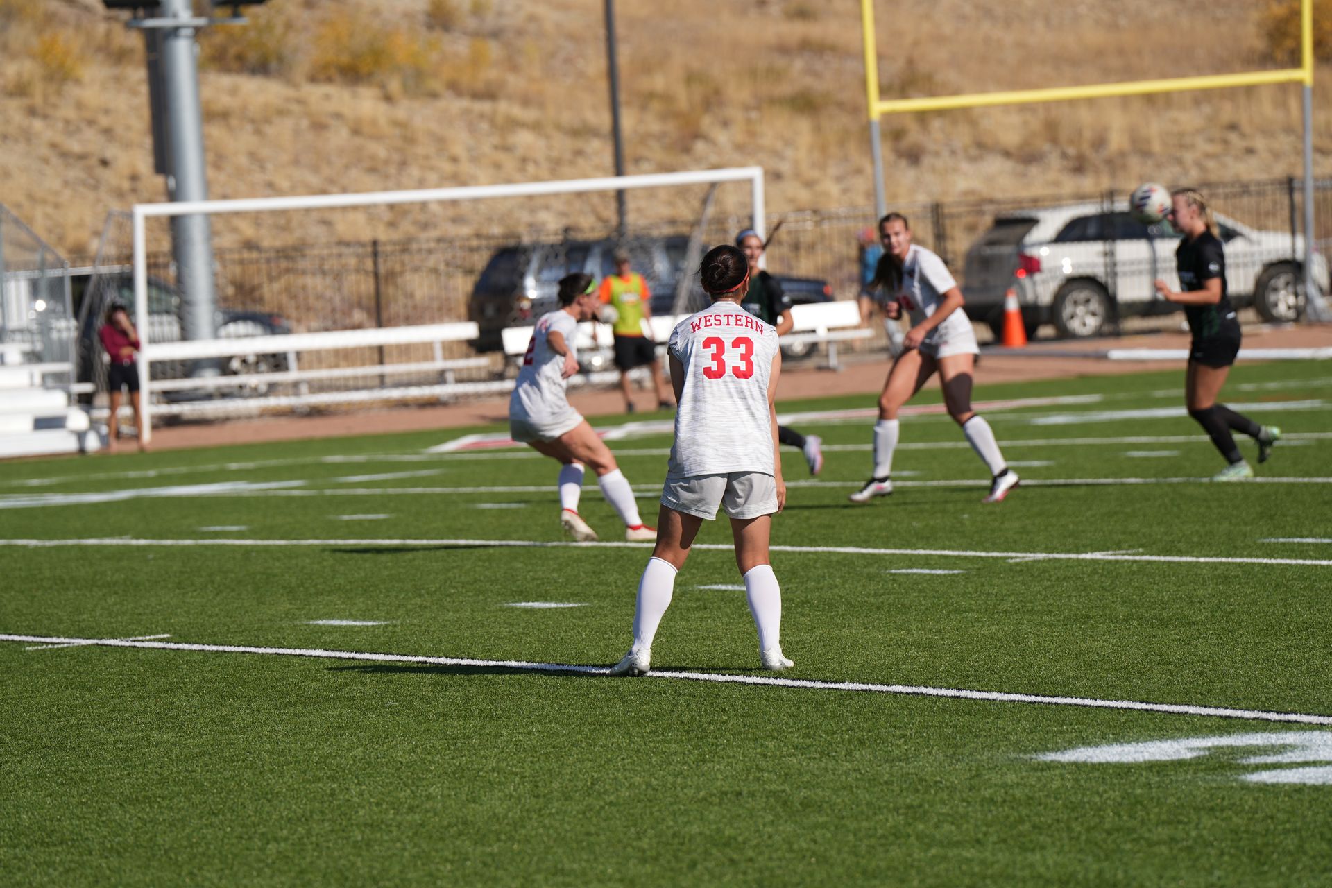 A group of women are playing soccer on a field.
