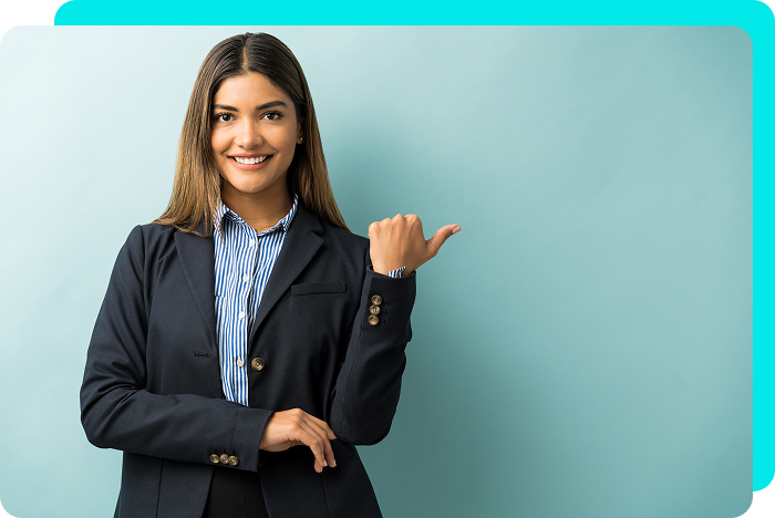 Woman in blazer and striped shirt, smiling and pointing to the right, against a light blue backdrop.