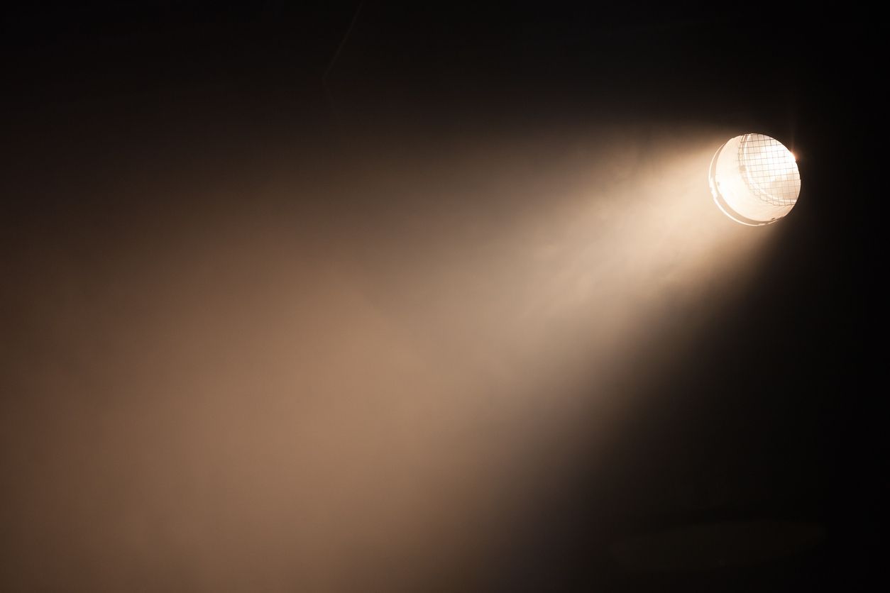Image of a spotlight lighting up a dark stage