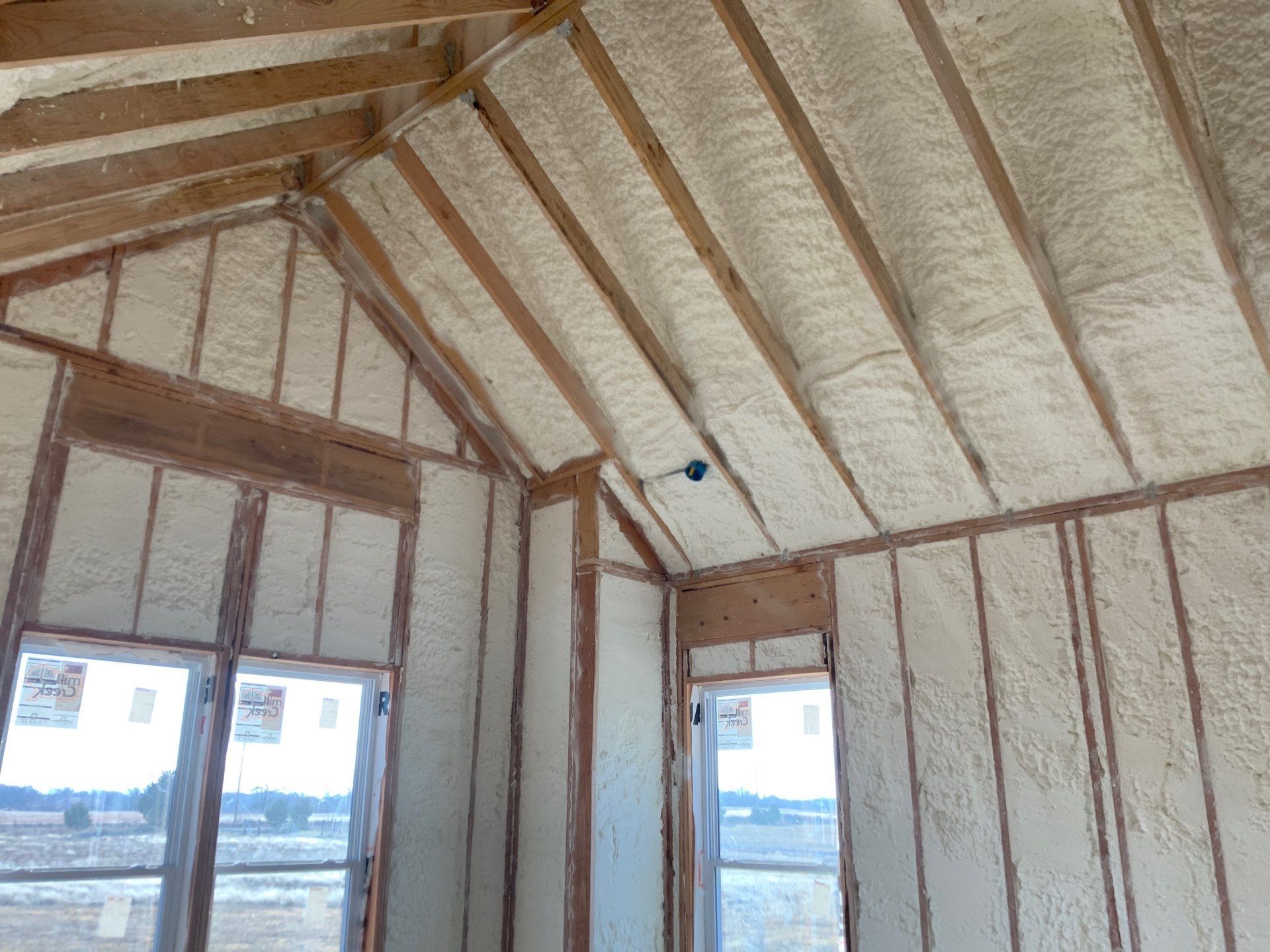 A room with a vaulted ceiling and walls covered in spray foam.