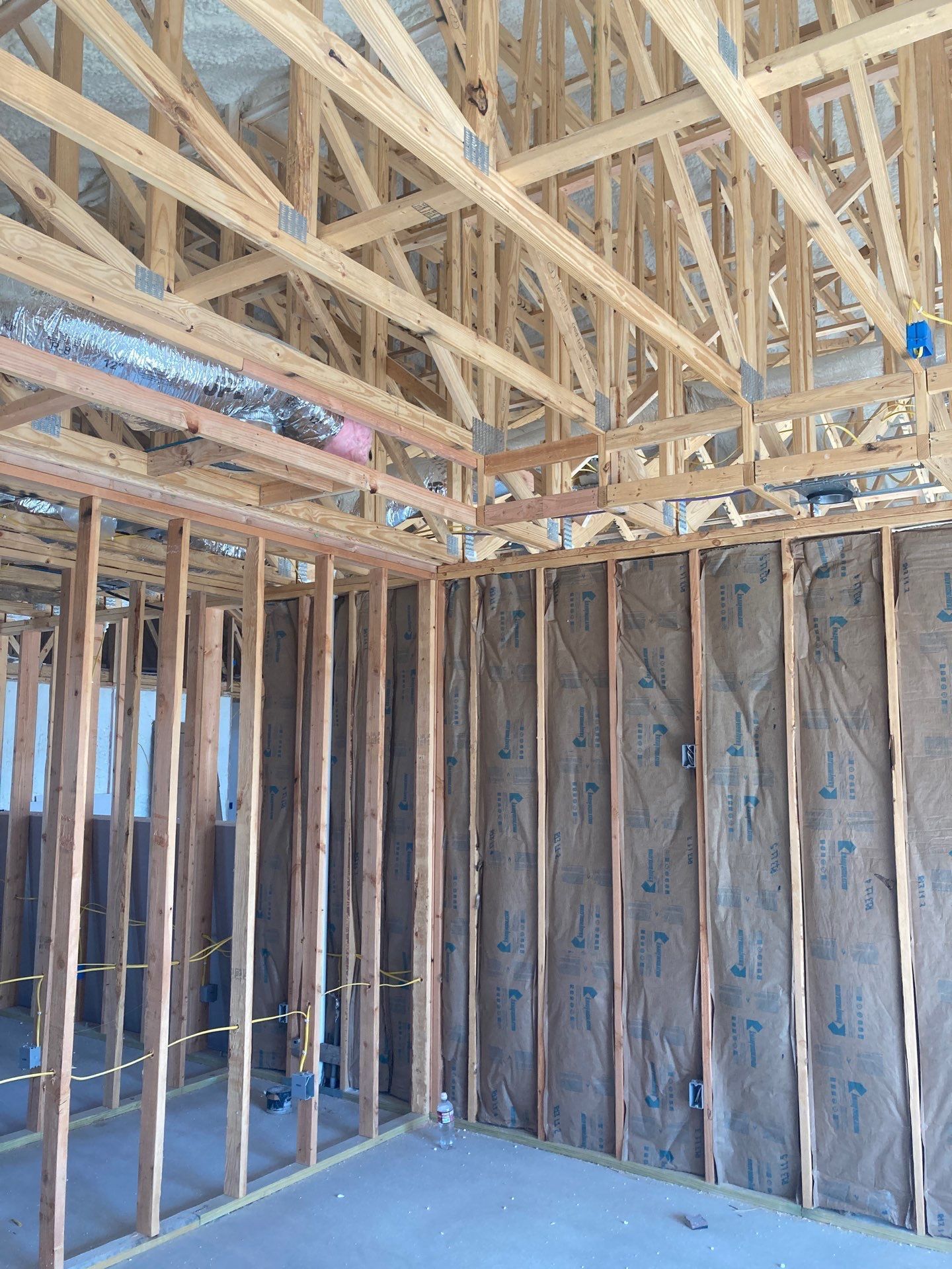 A room under construction with wooden beams and insulation.